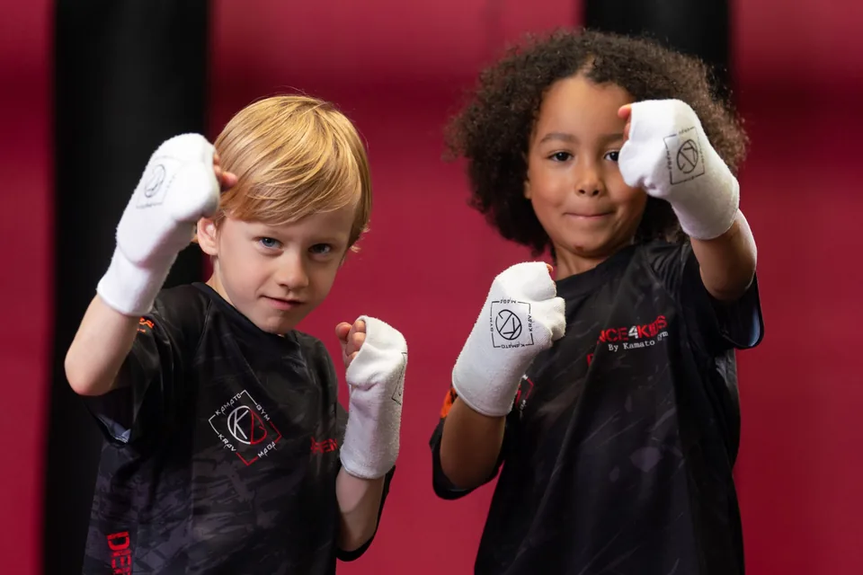 Twee kinderen met bandages om hun handen staan in gevechtshouding
