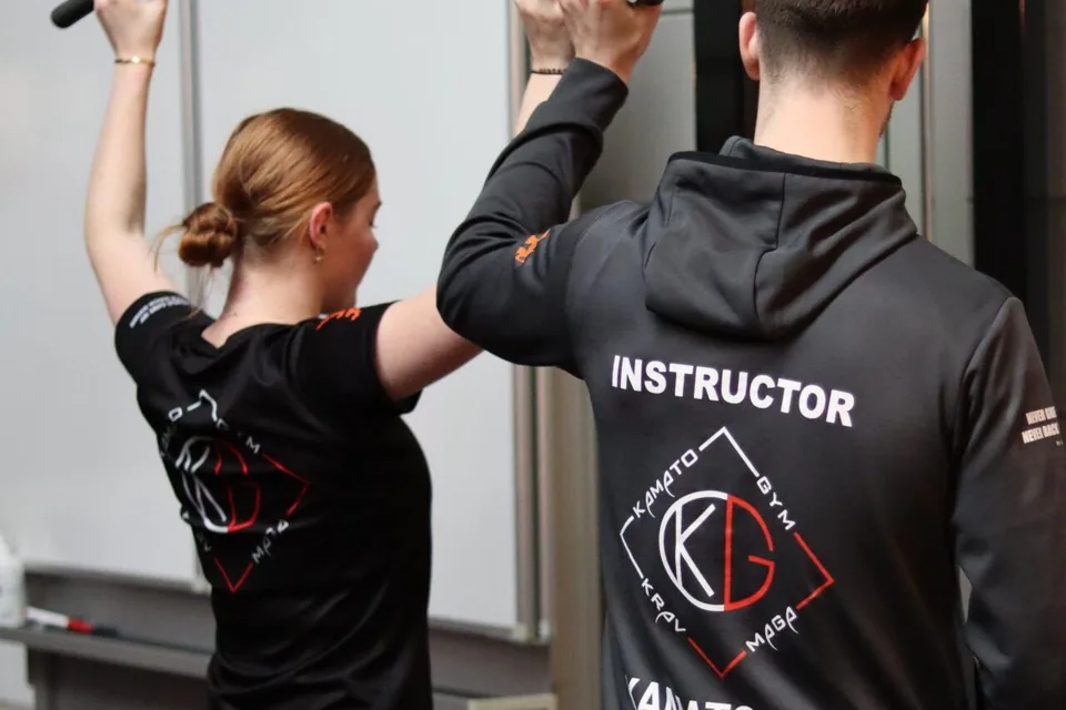 Een instructeur begeleidt één cursiste bij een techniek